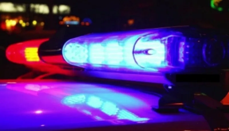 Un barral de luces de patrullero encendido con destellos azules y rojos sobre el techo de un móvil policial.