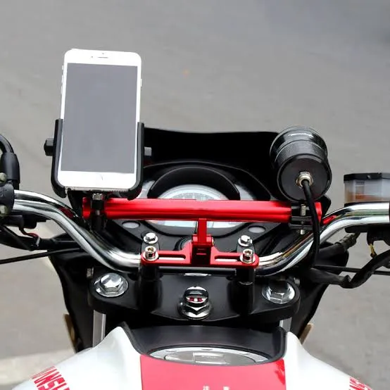 El manubrio de una moto con un soporte sosteniendo un celular y un accesorio cilindrico instalados.