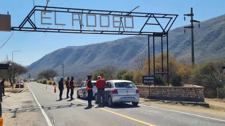 Efectivos policiales controlan vehículos en la ruta bajo un cartel que dice El Rodeo.