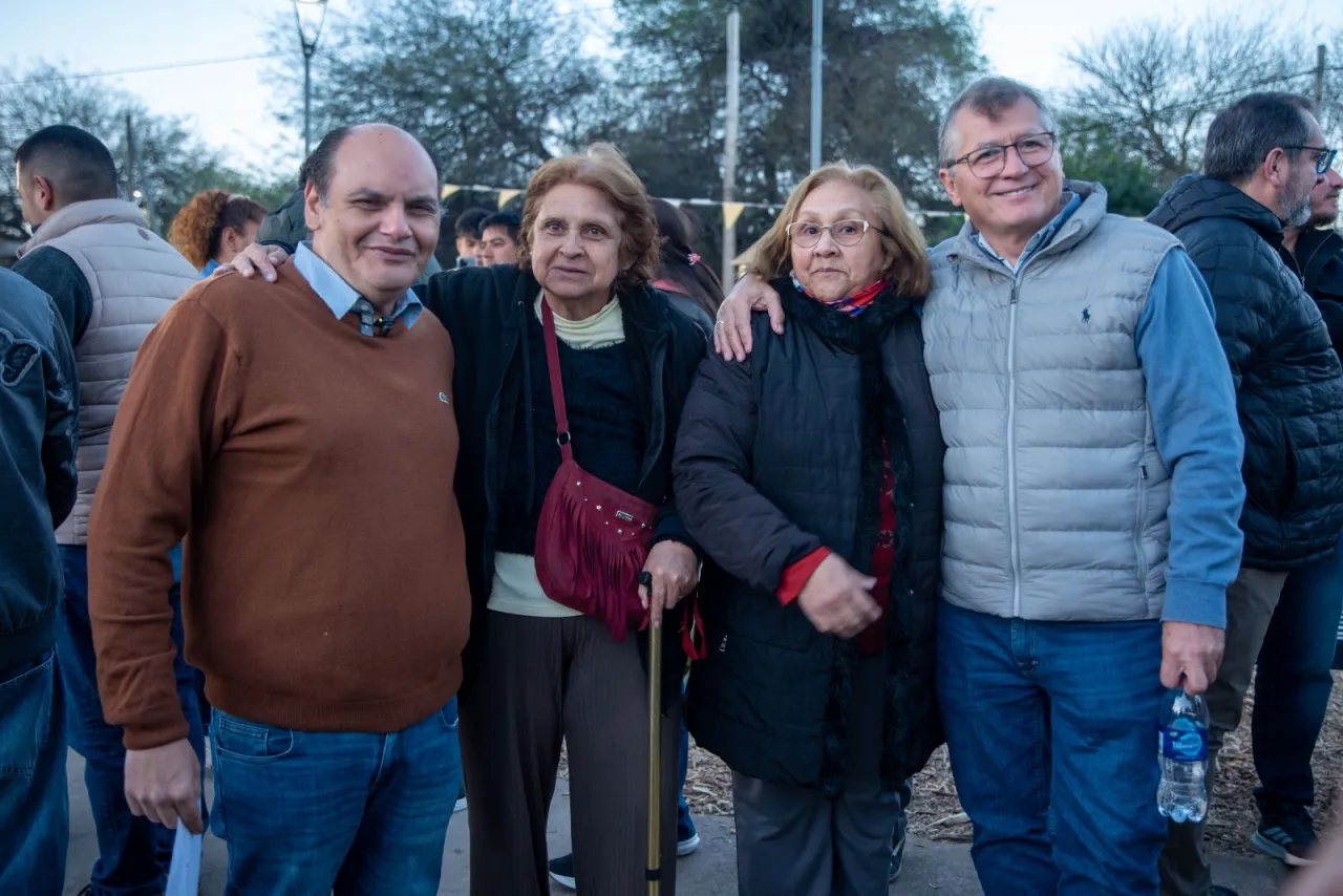 El intendente Gustavo Saadi posa sonriente junto a tres vecinos en un espacio público.