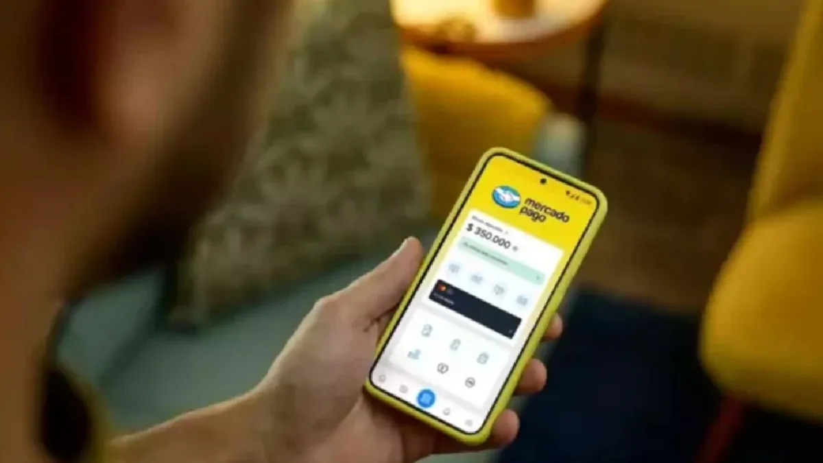 Una persona sosteniendo un celular con la aplicación de Mercado Pago abierta en la pantalla.