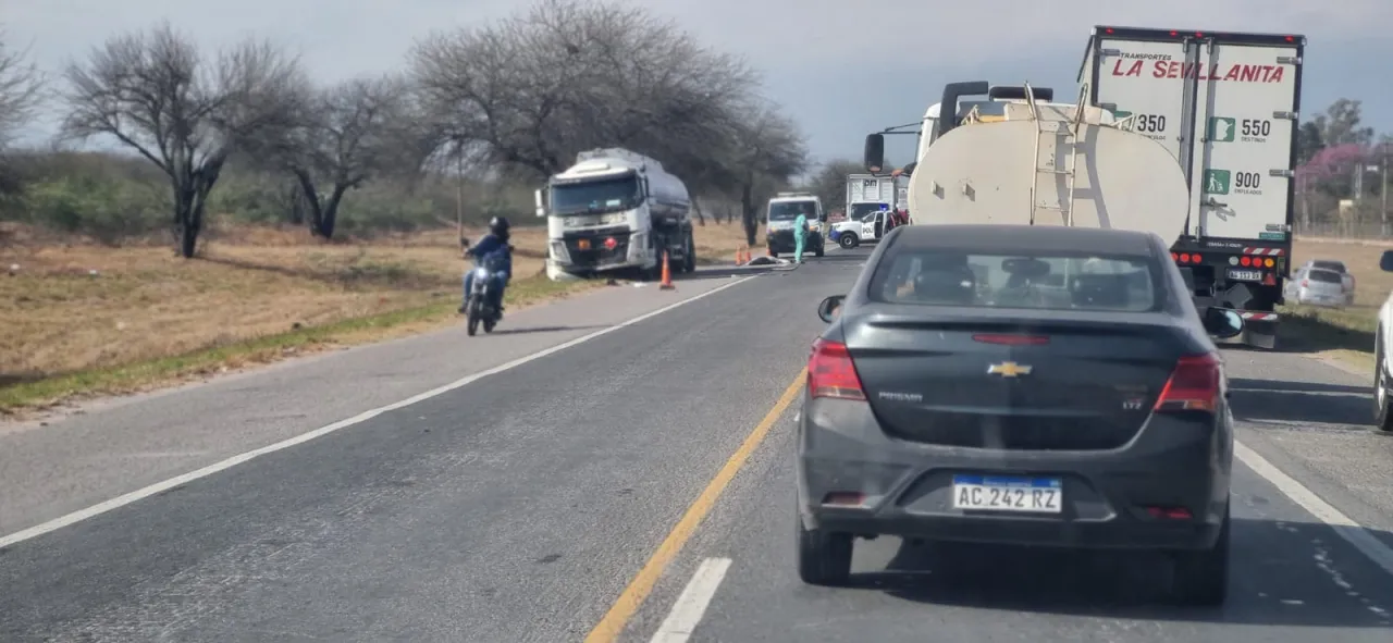 Autos, camiones y una moto circulan y se detienen sobre una ruta donde hay un camión cisterna al costado del camino.