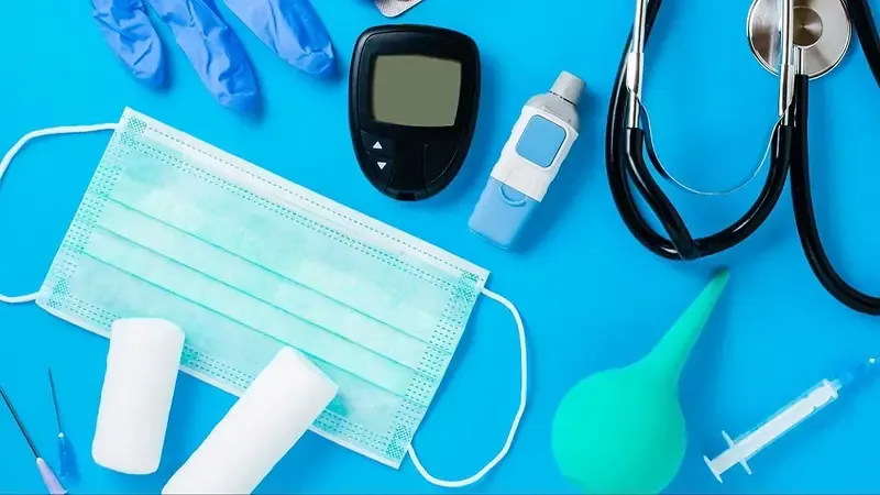 Elementos médicos e insumos de salud dispuestos sobre un fondo celeste.