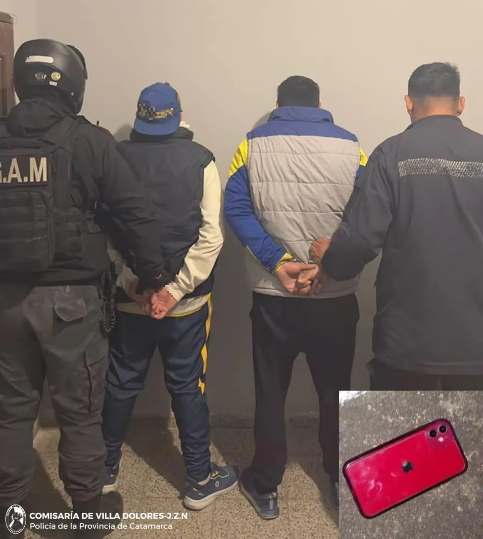 Dos personas detenidas permanecen de espaldas contra la pared custodiadas por policías.