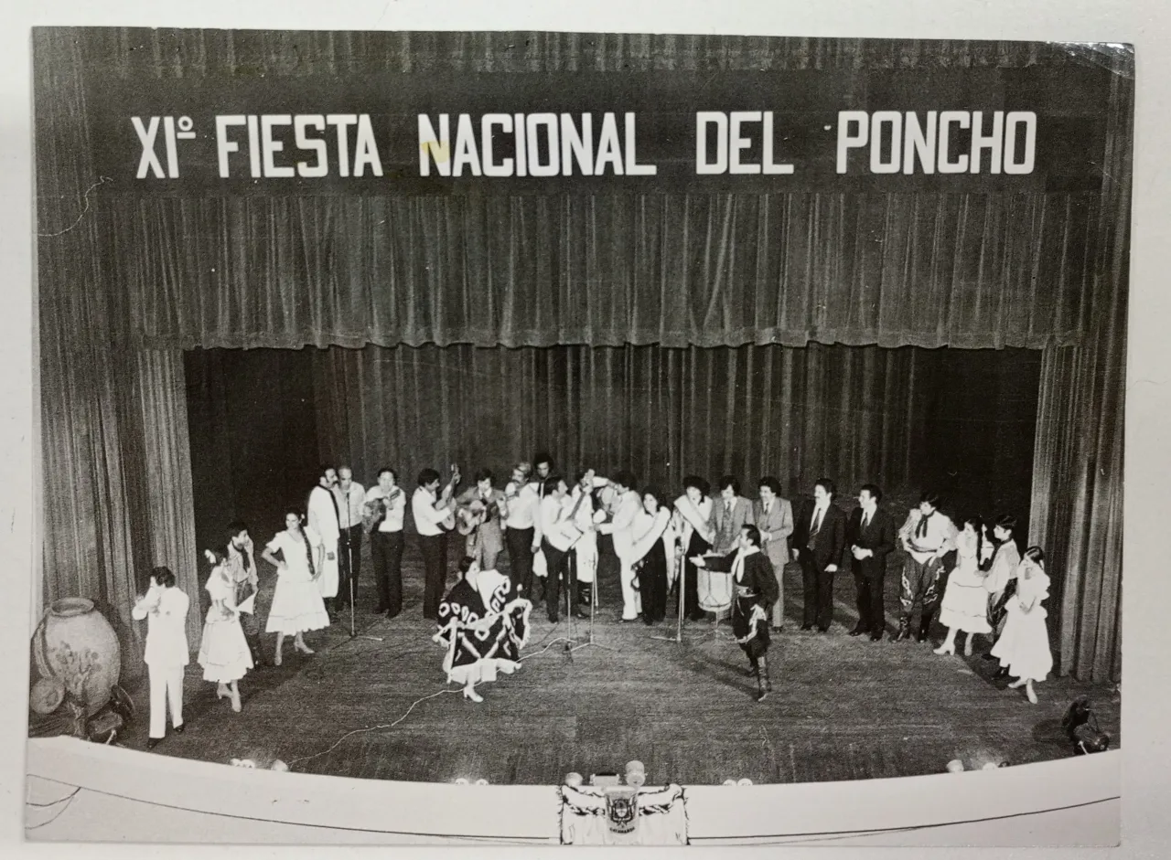 Grupo folclórico y bailarines en el escenario de la Fiesta Nacional del Poncho.