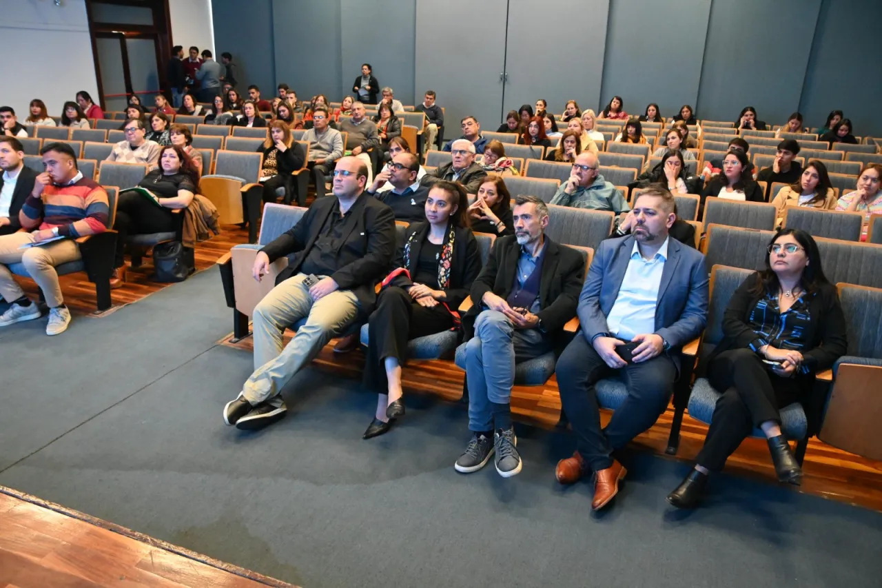 Un grupo de personas sentadas en las butacas de un auditorio mirando hacia el frente.