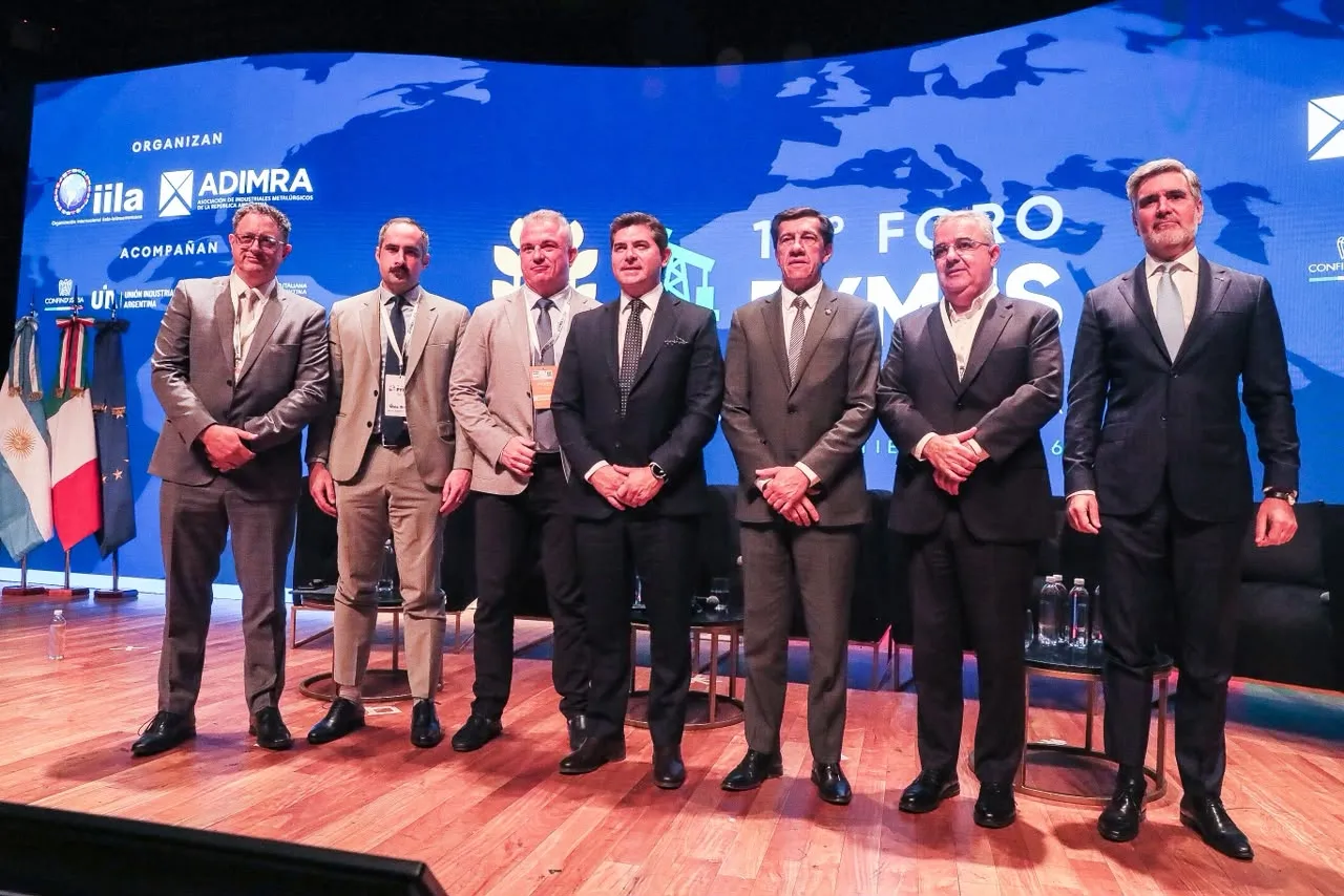 Raúl Jalil y varios participantes posan de pie en el escenario del 10° Foro PYMES Italia-América Latina.