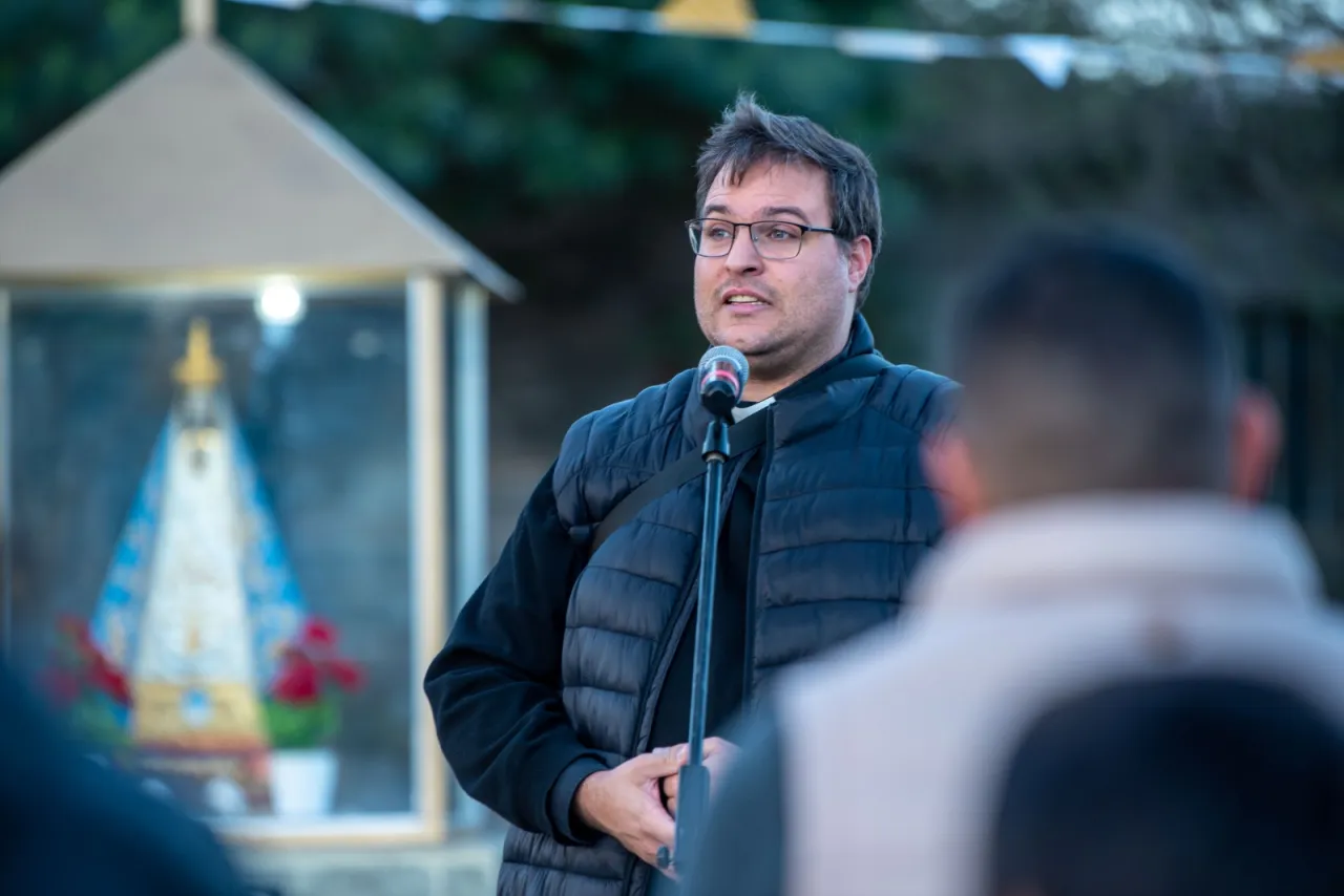 Un sacerdote habla por micrófono frente a una imagen de la Virgen del Valle.