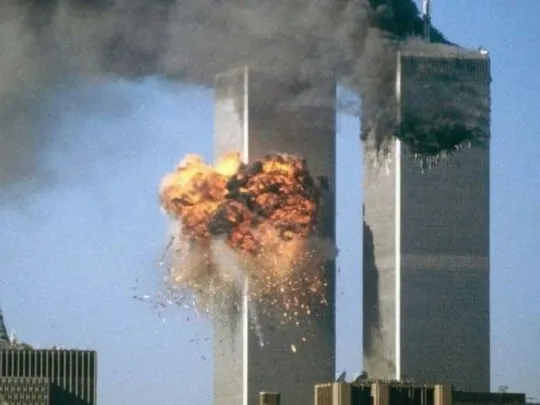 Una enorme bola de fuego y humo estalla en una de las Torres Gemelas mientras la otra torre humea.