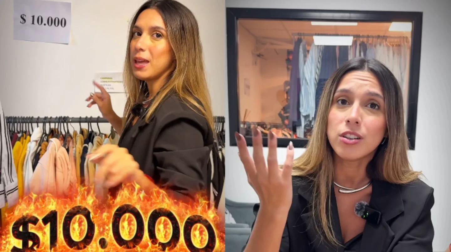 Una mujer habla gesticulando cerca de un perchero con ropa y carteles de precios.
