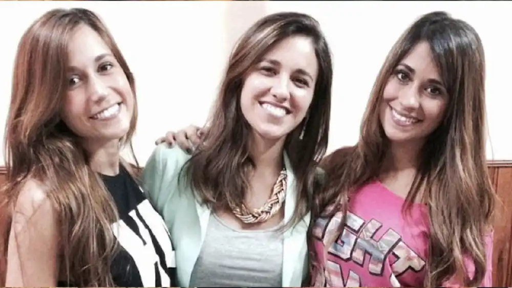 Antonela Roccuzzo sonriendo abrazada a sus dos hermanas, Carla y Paula.