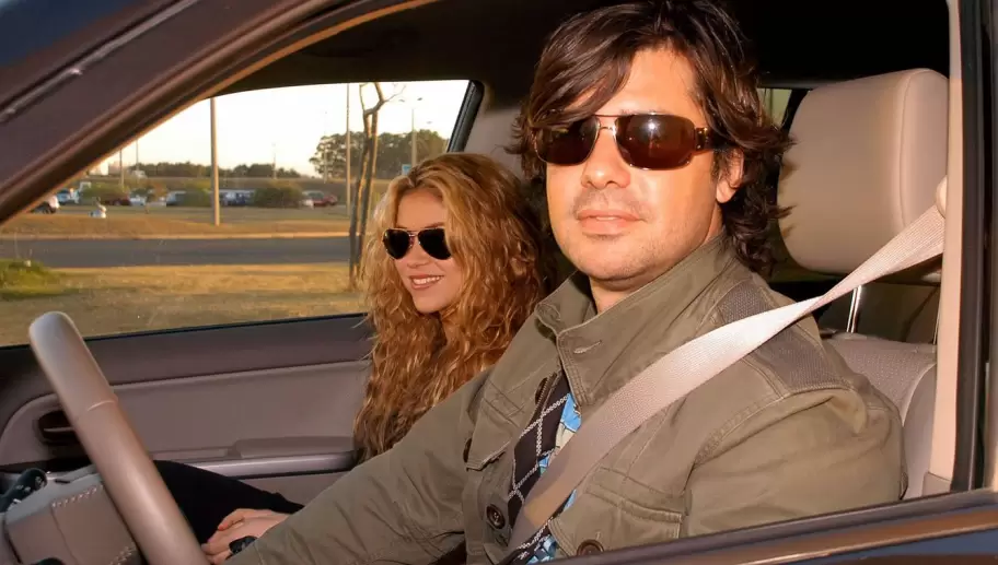 Antonio de la Rúa maneja un auto acompañado por Shakira en el asiento del acompañante.