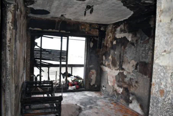 El interior de una habitacion con las paredes y el techo completamente quemados y restos carbonizados.
