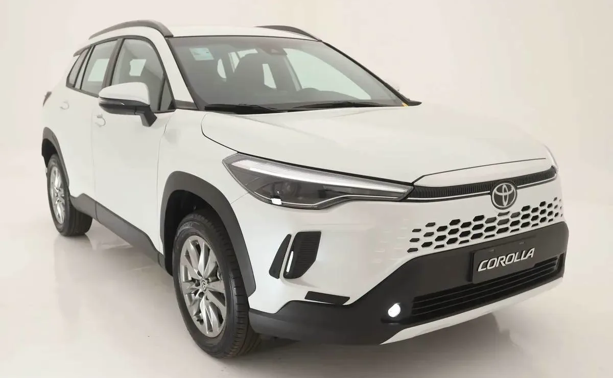 Una camioneta blanca tipo SUV estacionada en un estudio blanco vista de tres cuartos de perfil.