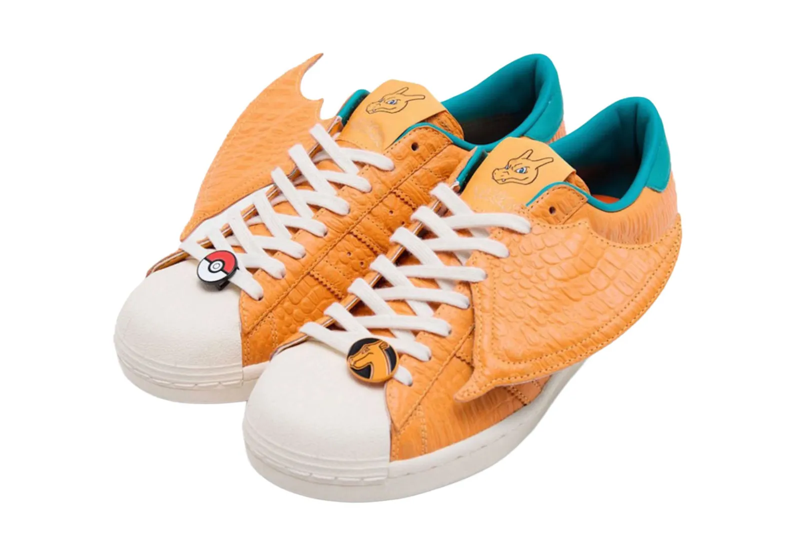 Par de zapatillas naranjas con textura de escamas y alas laterales inspiradas en el personaje de Pokemon Charizard.