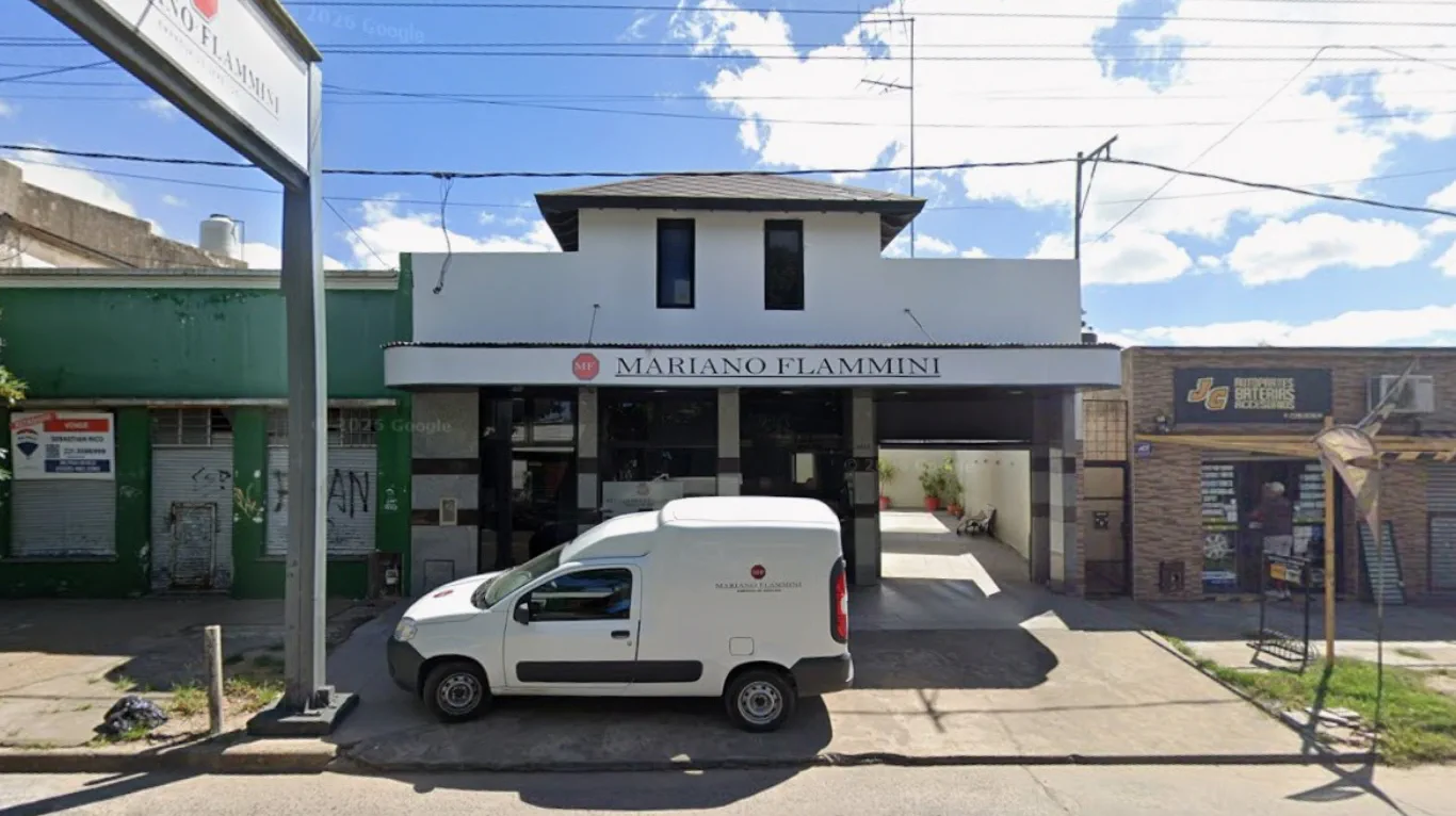 Frente de la casa de sepelios Mariano Flammini con una camioneta blanca estacionada en la entrada.