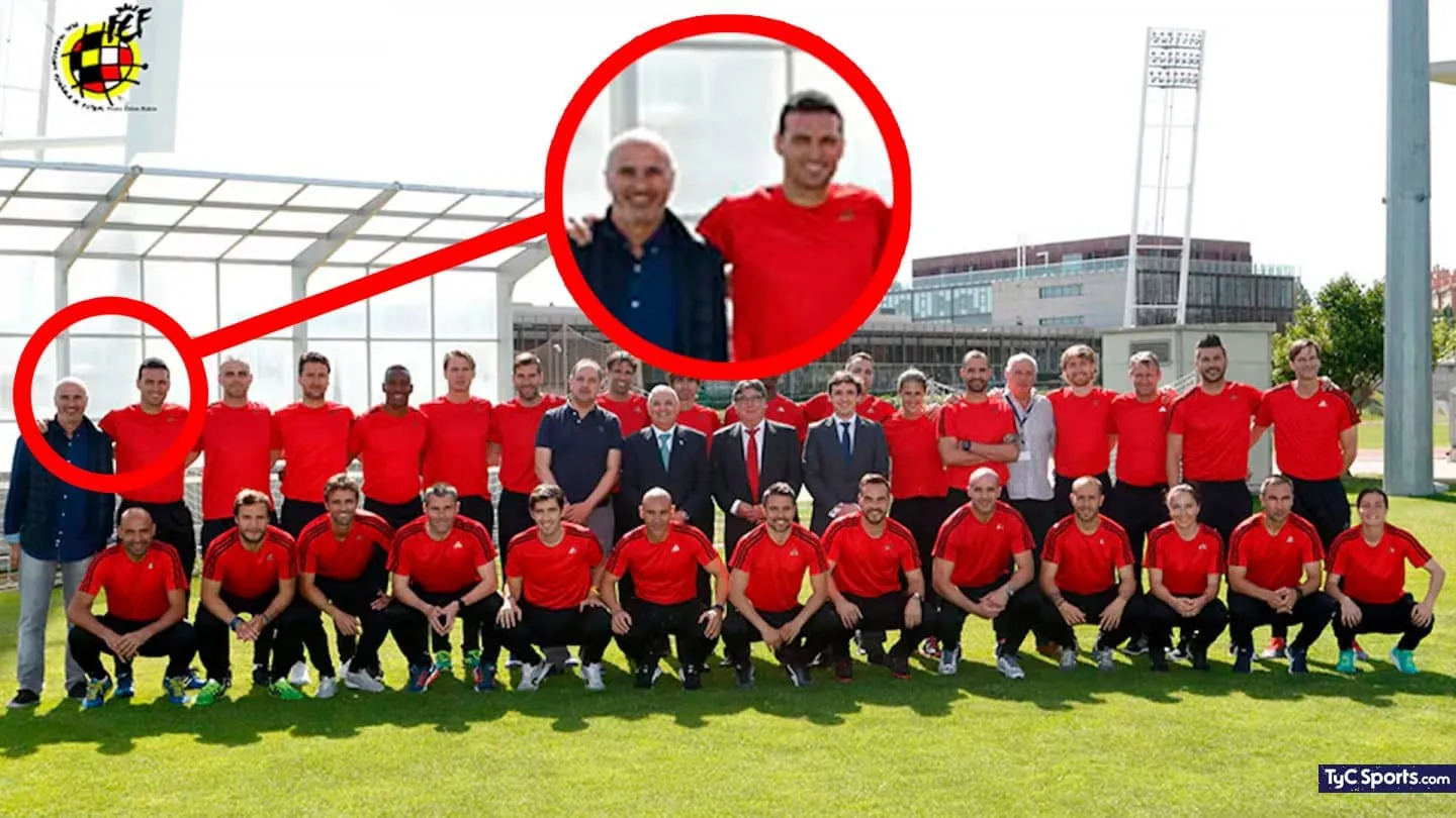 Un grupo de personas posa al aire libre en una cancha con remeras rojas y ropa formal junto a dos hombres destacados en rojo.