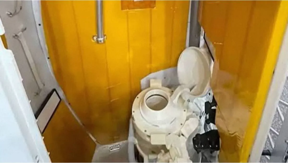 Un inodoro espacial en un habitáculo con paneles amarillos.