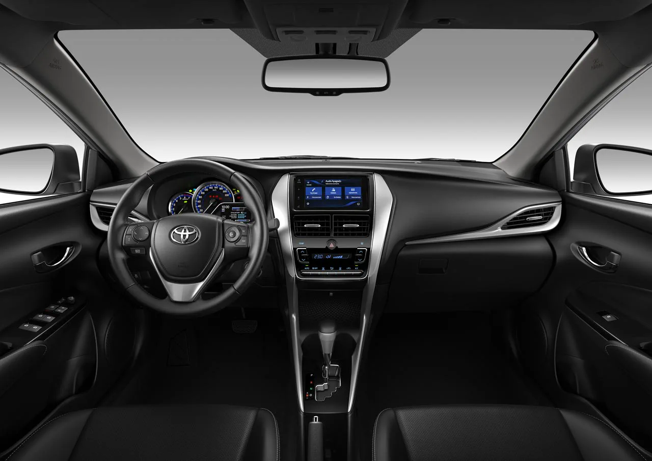 El tablero y habitáculo interior de un auto negro con volante multifunción y pantalla central.