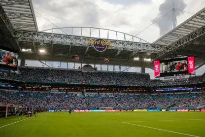 Tribunas llenas y campo de juego en el estadio Hard Rock Stadium bajo un cielo nublado durante un partido.