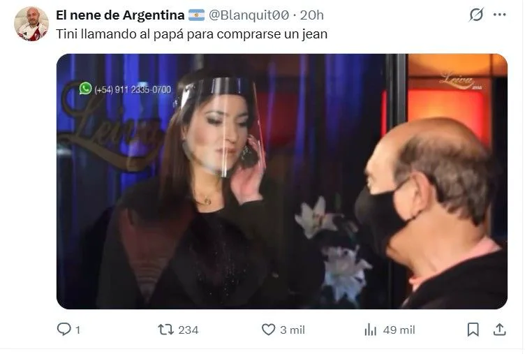 Una mujer con máscara facial habla por teléfono en un local mientras un hombre calvo con barbijo la mira.