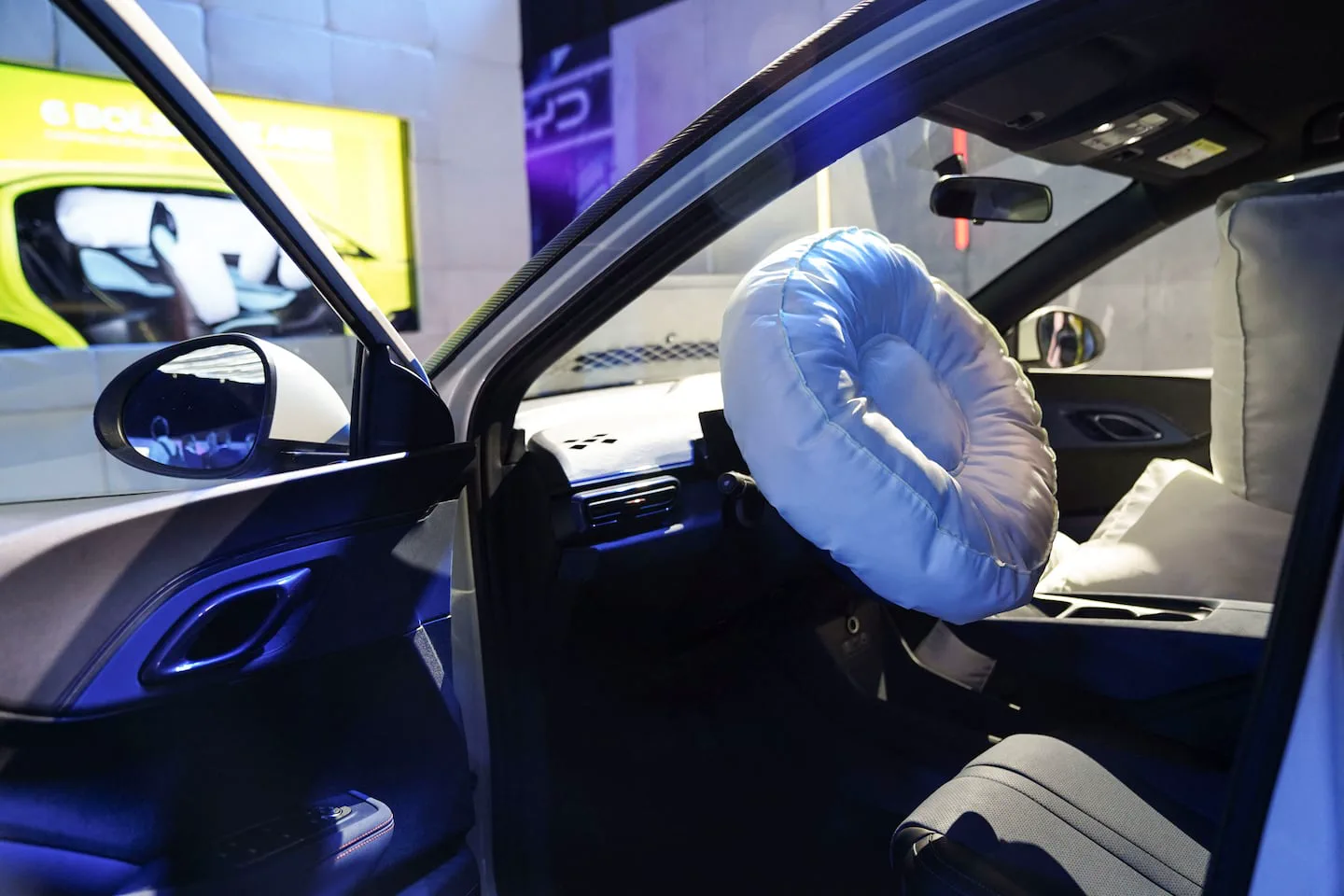 El interior de un auto con los airbags del volante y del acompañante completamente desplegados.