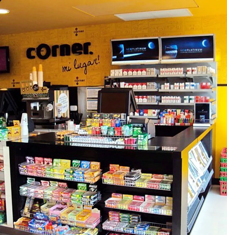 Mostrador de un kiosco con golosinas, cigarrillos en exhibidores y un cartel que dice Corner mi lugar.