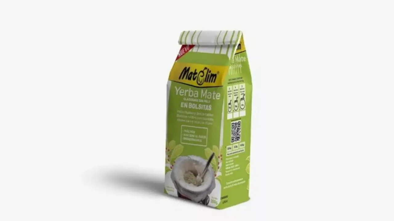 Un paquete de yerba mate en bolsitas sobre un fondo blanco junto a una taza con bombilla.
