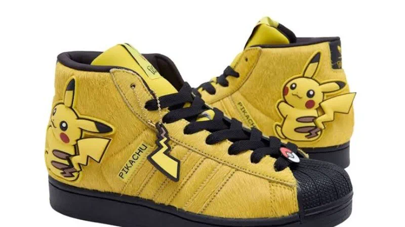 Zapatillas amarillas de caña media con textura de pelo y apliques del personaje Pikachu sobre un fondo blanco.