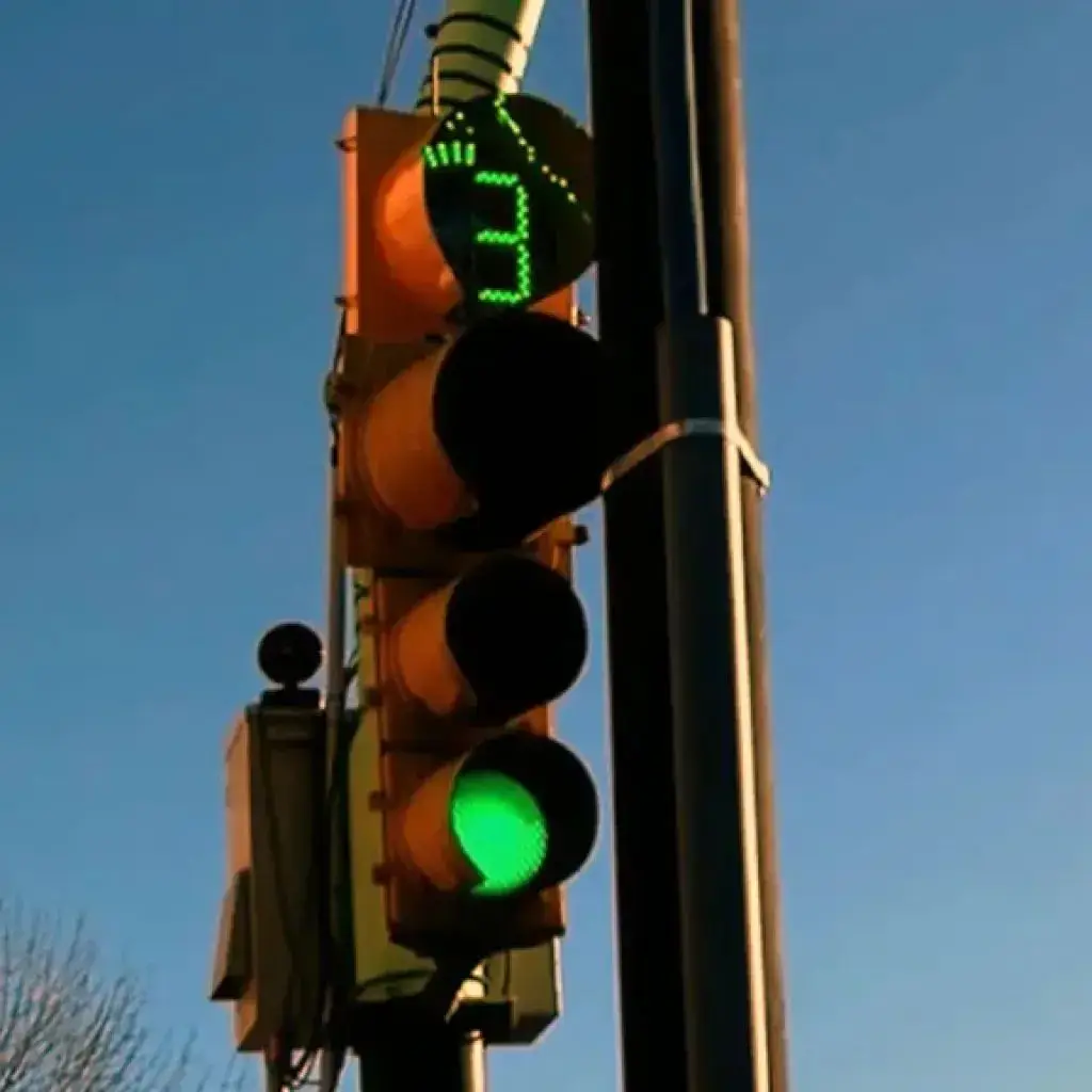 Un semáforo con luz verde encendida y un contador digital luminoso que marca el número tres.