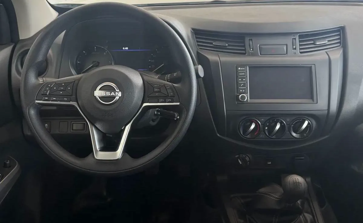 Interior de un vehiculo visto desde el asiento del conductor con el volante y el tablero.