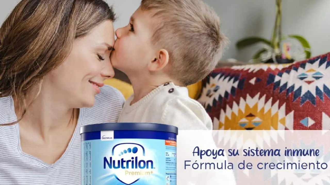 Un nene le da un beso en la frente a una mujer junto a una lata de fórmula infantil.