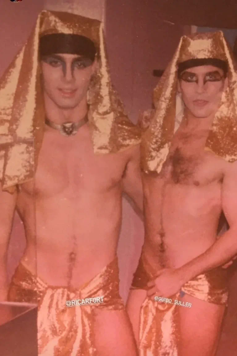 Ricardo Fort y Guido Suller disfrazados con atuendos egipcios dorados y maquillaje en los ojos.