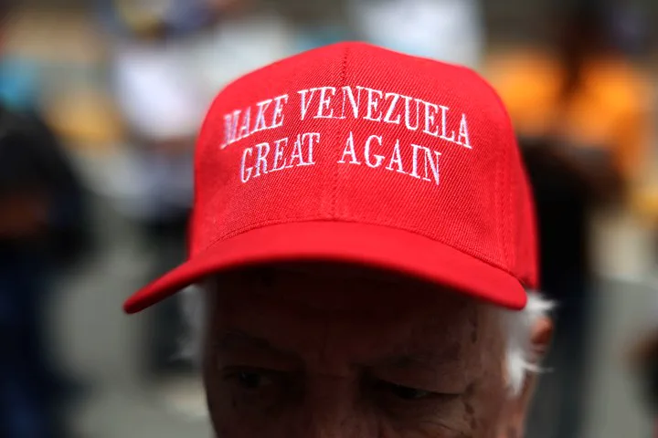 Primer plano de una persona mayor con una gorra roja que tiene bordada la frase Make Venezuela Great Again.