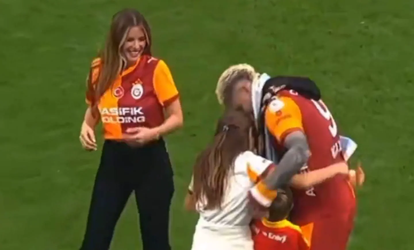 Mauro Icardi abrazando a unos niños en una cancha de fútbol junto a una mujer con la camiseta del Galatasaray.