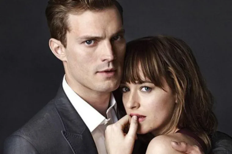 Los actores Jamie Dornan y Dakota Johnson posan abrazados mirando al frente.