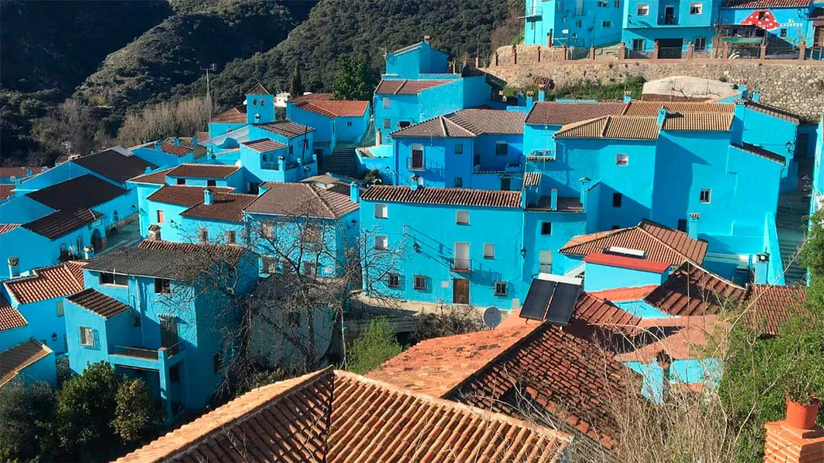 Casas con paredes pintadas de celeste y techos de tejas en un pueblo de montana.