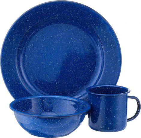 Un plato hondo, un plato playo y un jarro de chapa enlozada azul con motas blancas sobre fondo blanco.