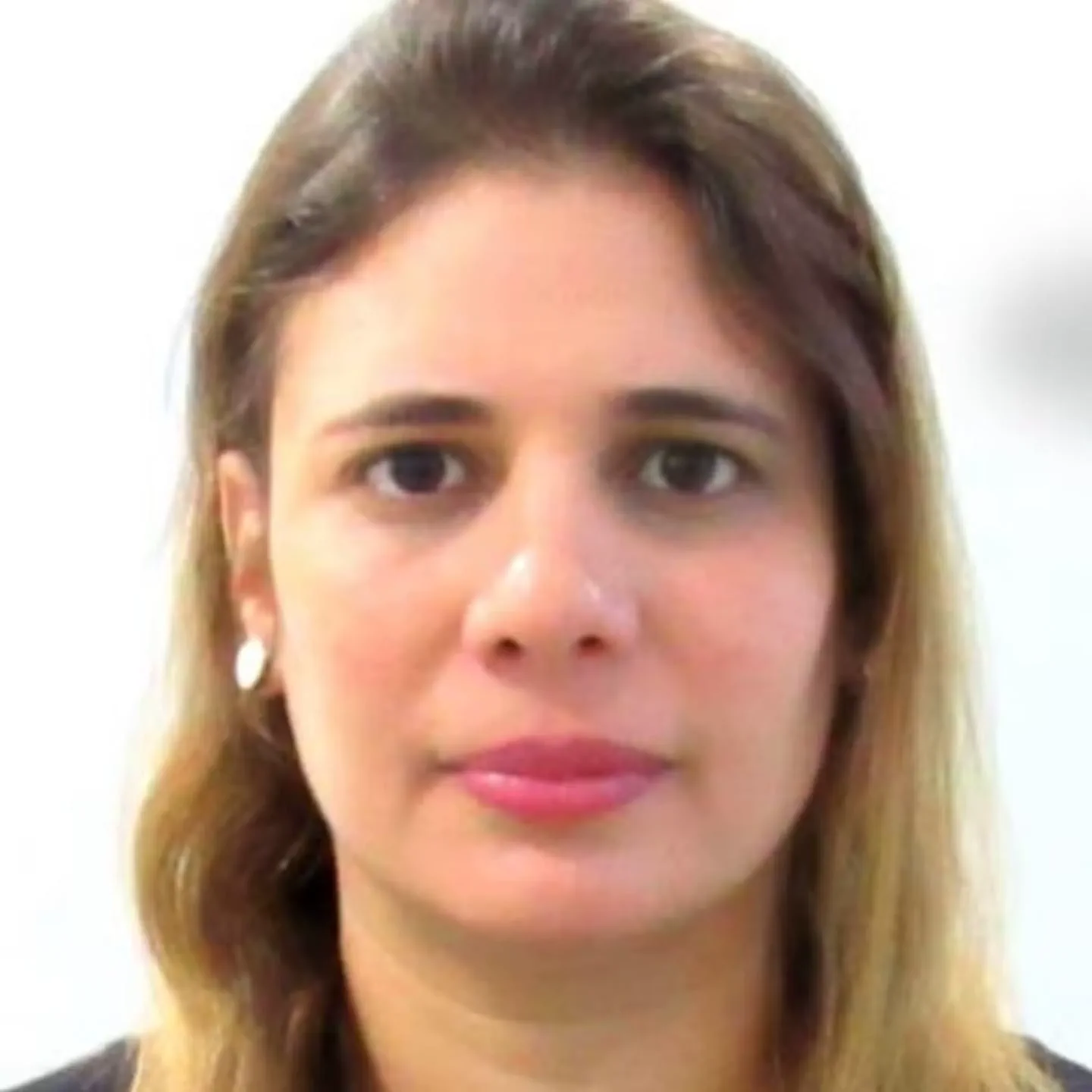 Primer plano del rostro de una mujer de cabello castaño claro mirando hacia adelante sobre fondo blanco.