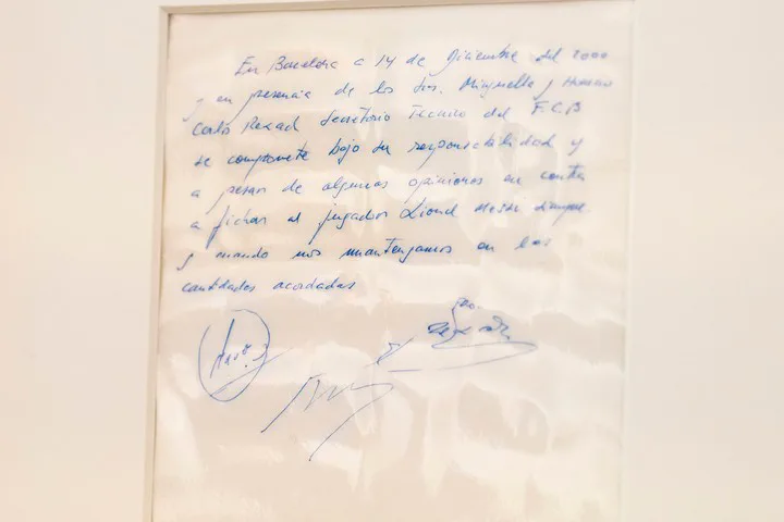 Una servilleta enmarcada exhibe un contrato manuscrito firmado con tinta azul para fichar a Lionel Messi.