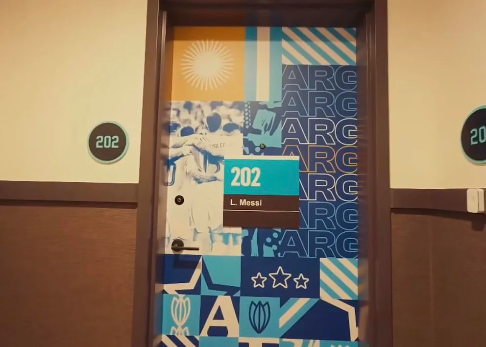 Una puerta de hotel decorada con motivos de la seleccion argentina lleva un cartel con el nombre L. Messi y el numero 202.