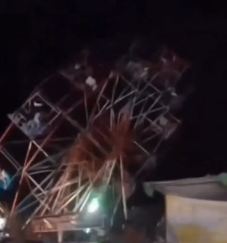 Una vuelta al mundo gira de noche en un parque de diversiones iluminado.