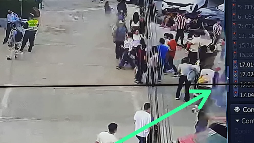 Captura de pantalla de una cámara de seguridad que muestra personas en la vía pública con una flecha verde.