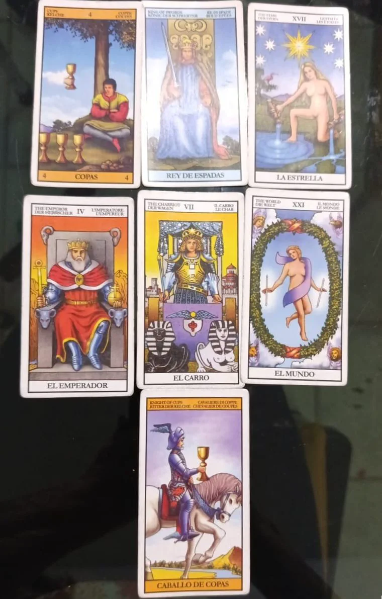 Siete cartas de tarot del mazo Rider-Waite están dispuestas sobre una mesa.