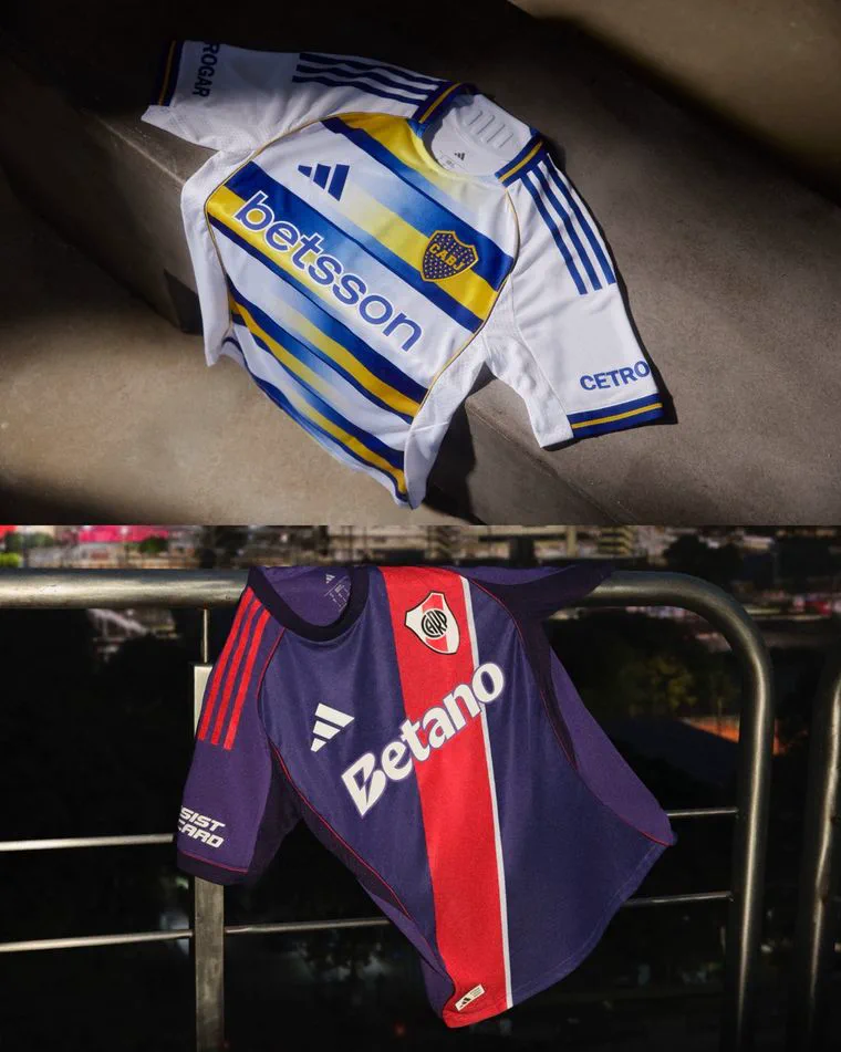 Camisetas de futbol de Boca Juniors y de River Plate exhibidas sobre una superficie de cemento y una baranda.