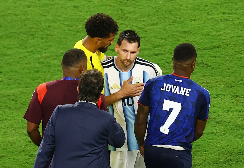Lionel Messi con la camiseta de la seleccion argentina rodeado por otros jugadores en la cancha.