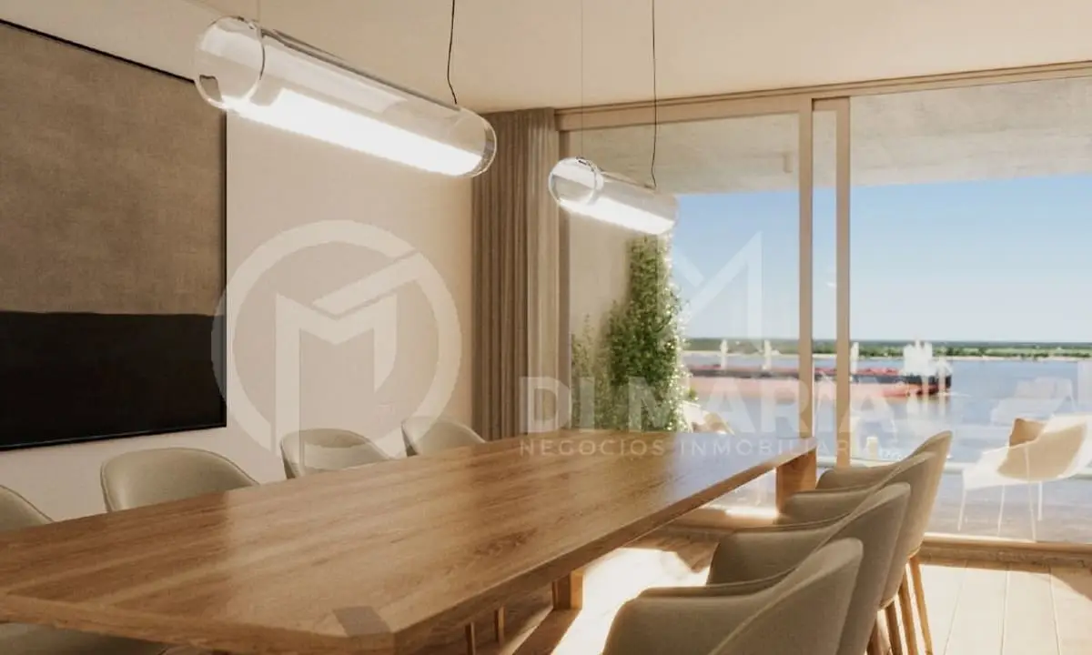 Una mesa de madera larga con sillas en un comedor amplio con vista al río a través de un ventanal.