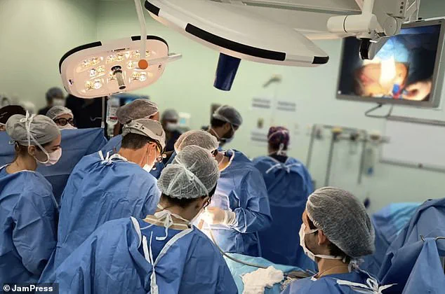Equipo de cirujanos con ambos y barbijos realizando una intervención dentro de un quirófano.