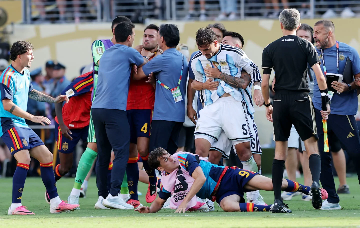 Rodrigo De Paul y otros futbolistas de Argentina y España forcejean y discuten en la cancha.