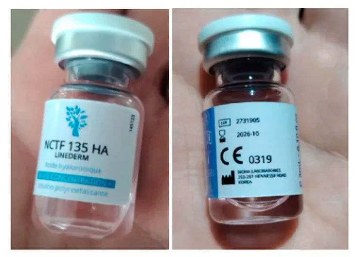 Dos frascos de vidrio con etiquetas médicas de NCTF 135 HA sostenidos con una mano.